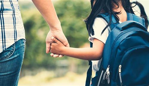 Girl biwht backpack holding parents hand